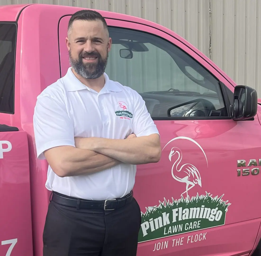 A man standing in front of a pink truck.
